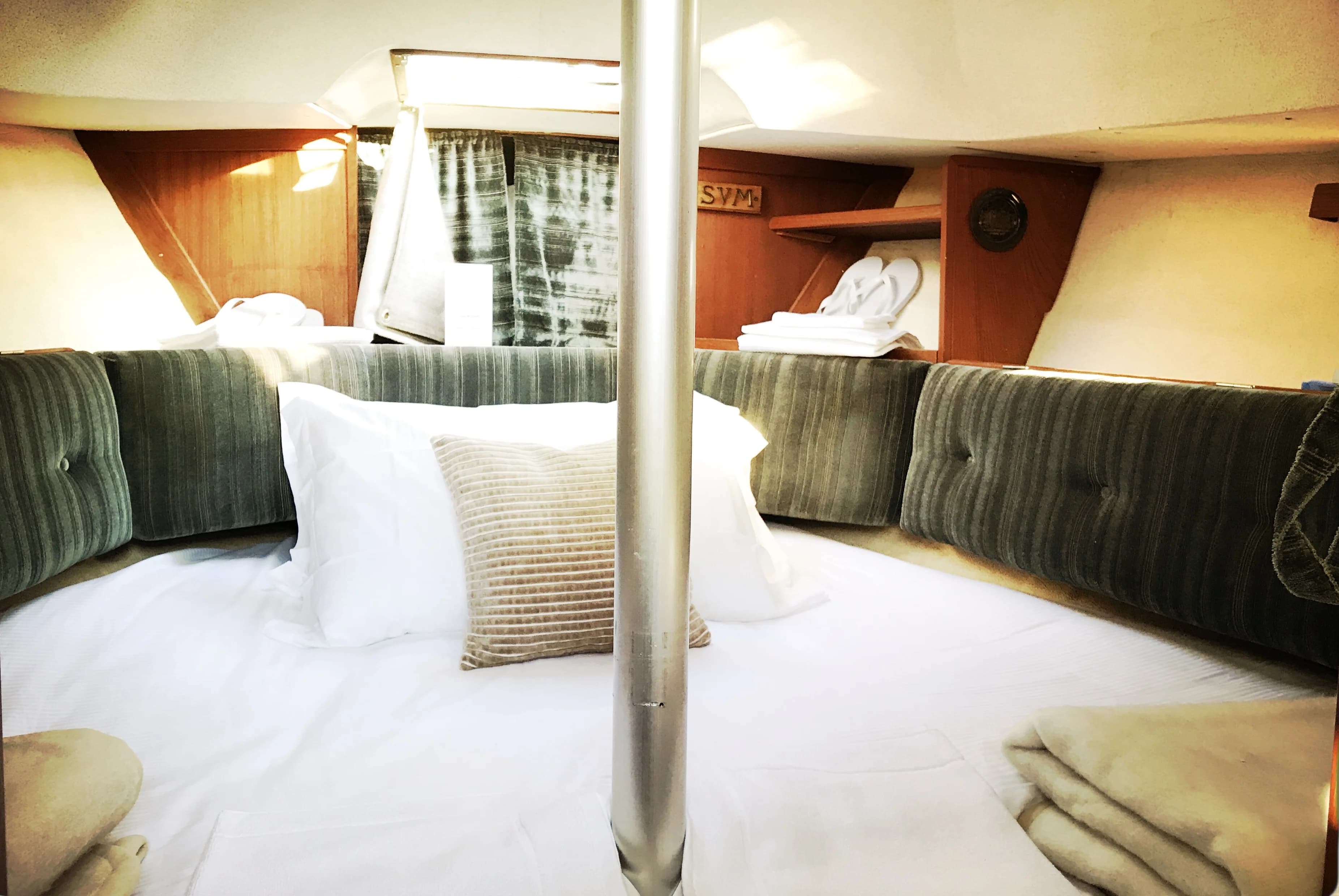 V-berth cabin bed with green upholstery