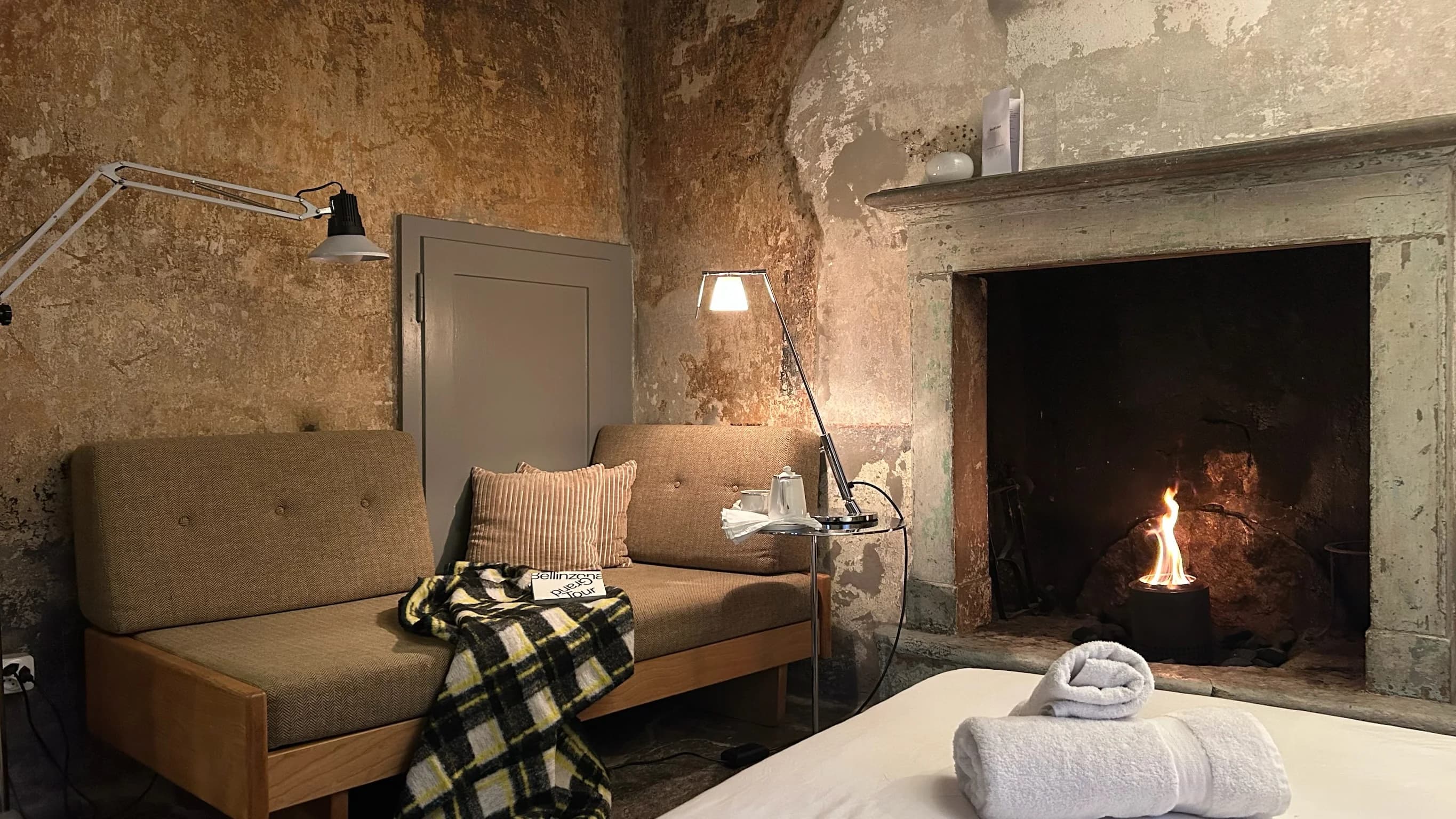 Mini suite lounge with fireplace and bed linens