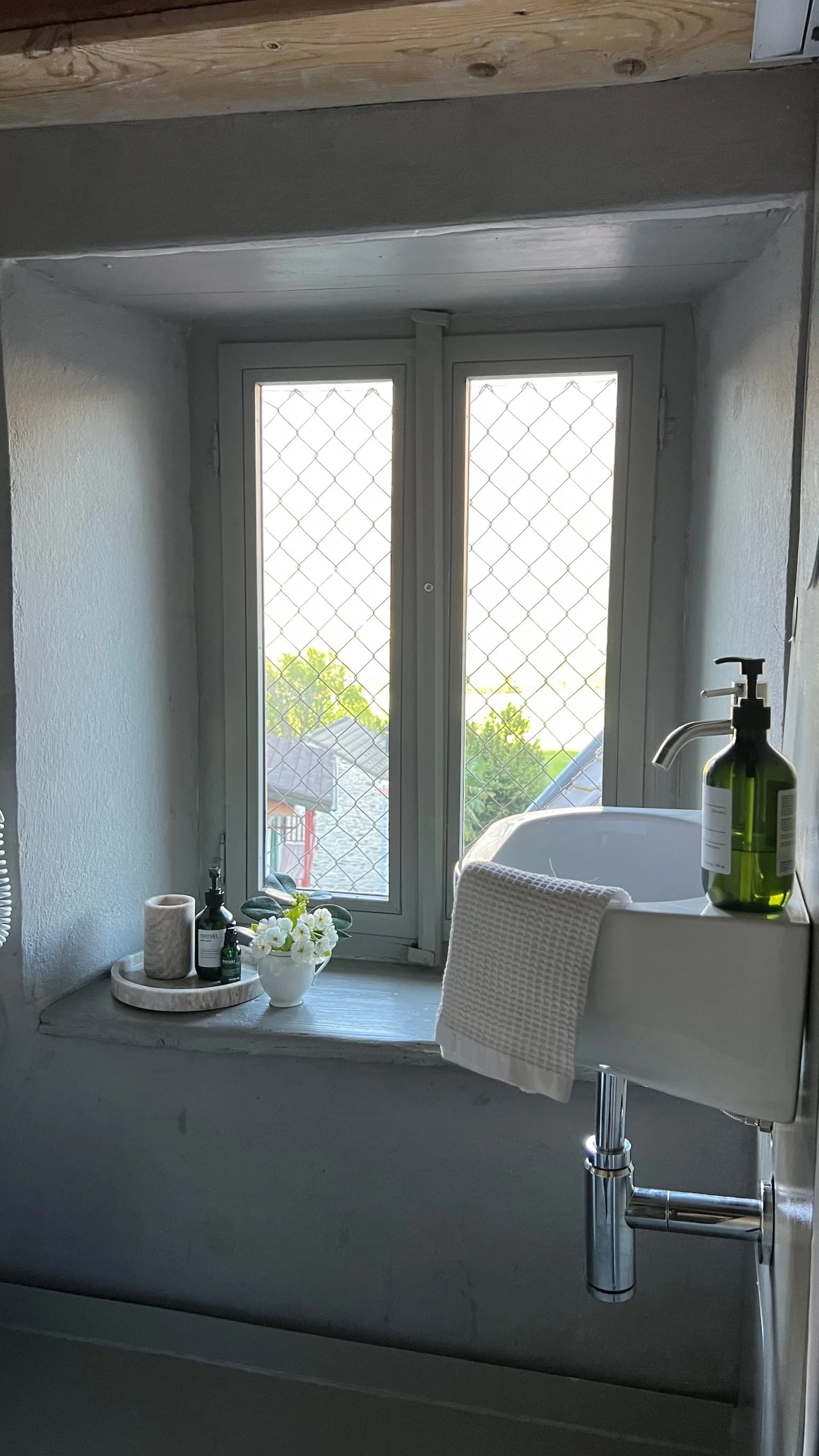 Bathroom sink beside a village-facing window