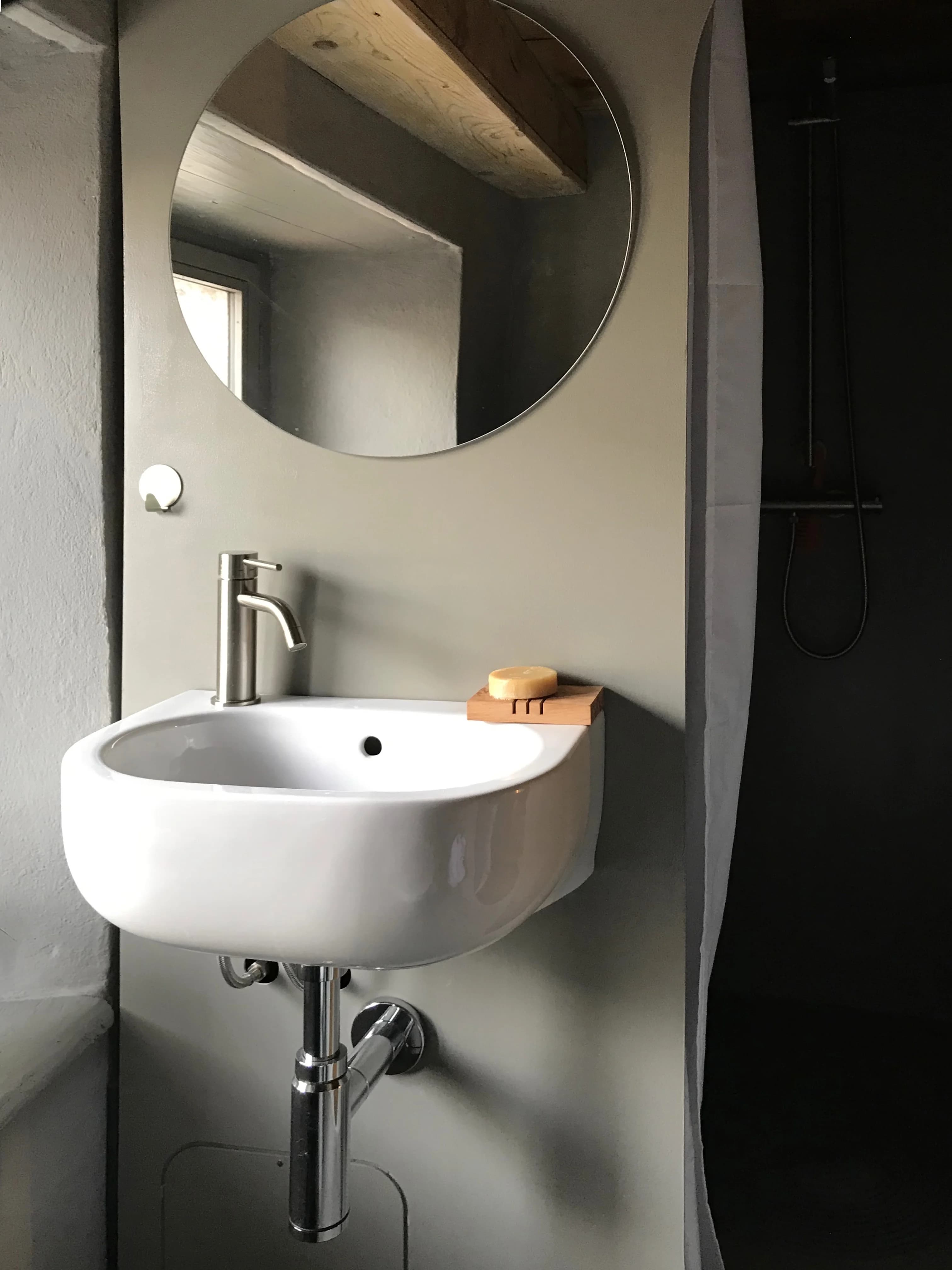 Suite bathroom vanity with round mirror and shower