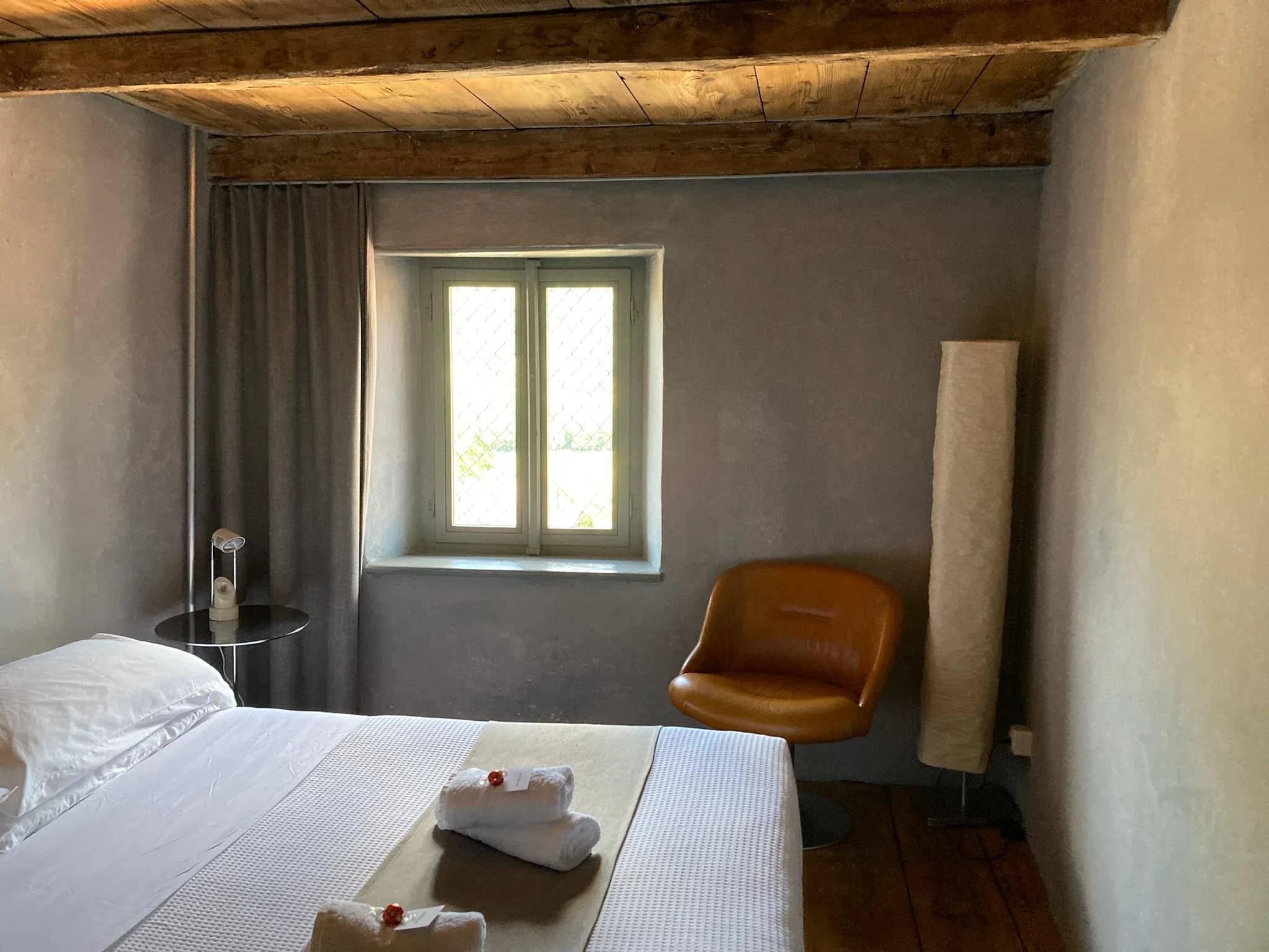 Suite bedroom with leather chair and timber beams