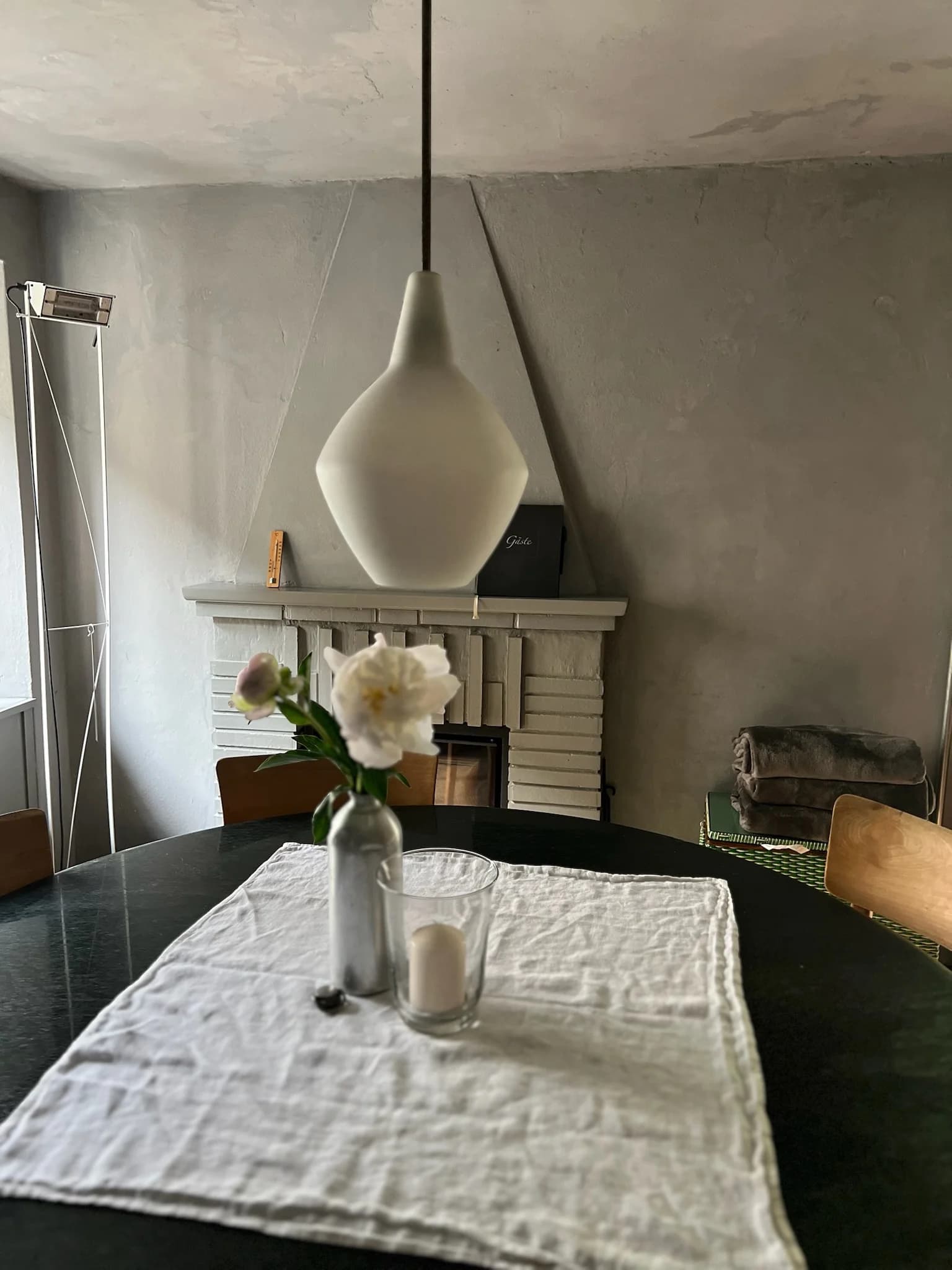 Dining table detail beneath a sculptural pendant lamp