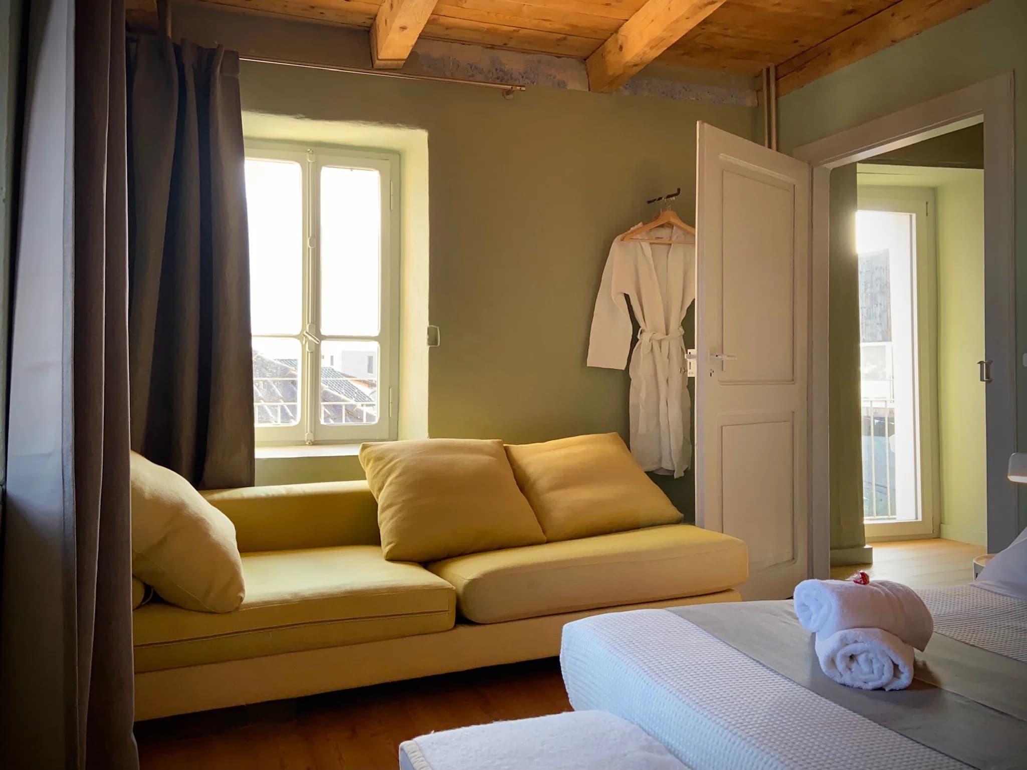 Guest room with yellow daybed and robe